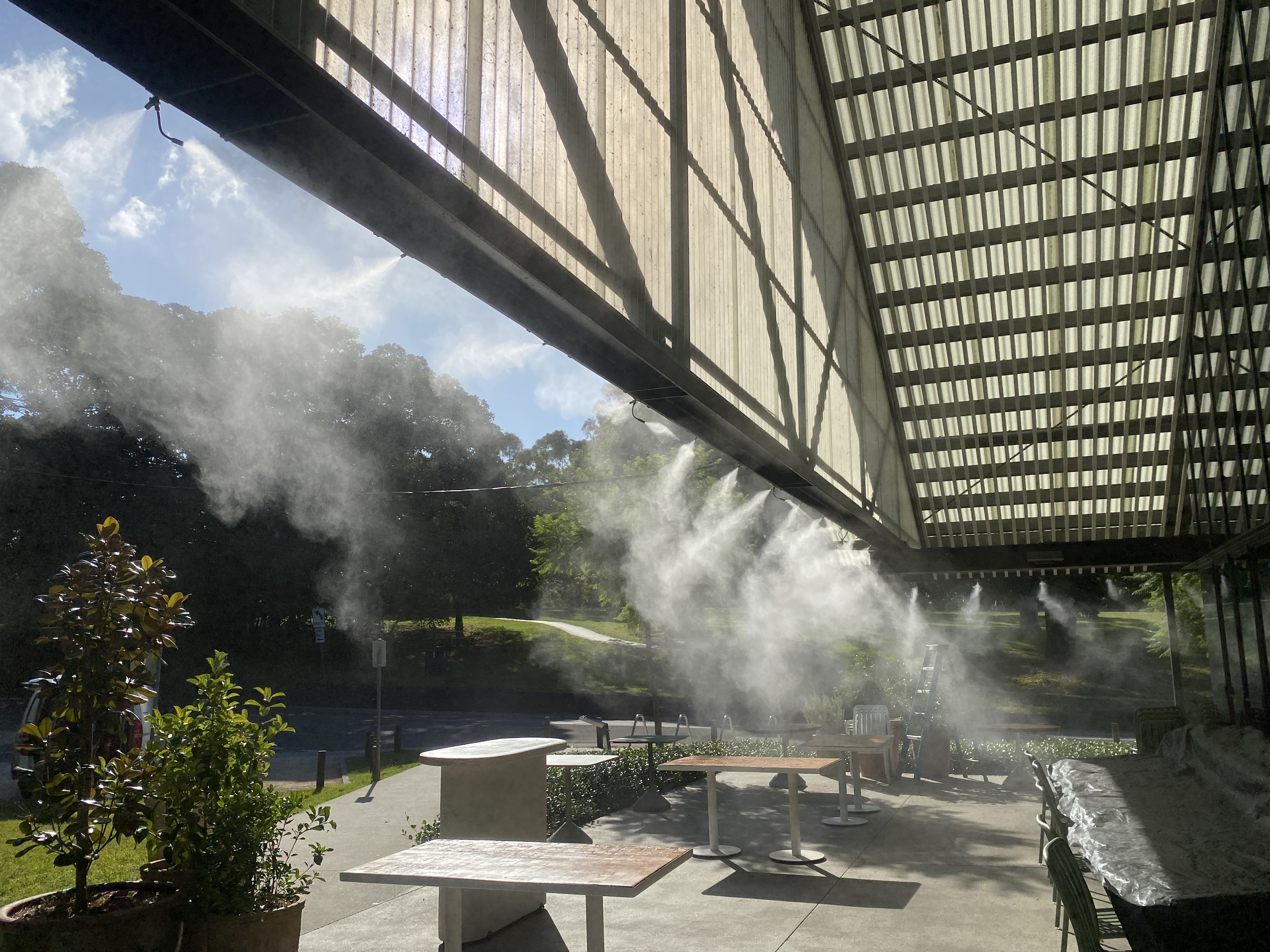 Fixed perimeter misting lines under industrial canopy